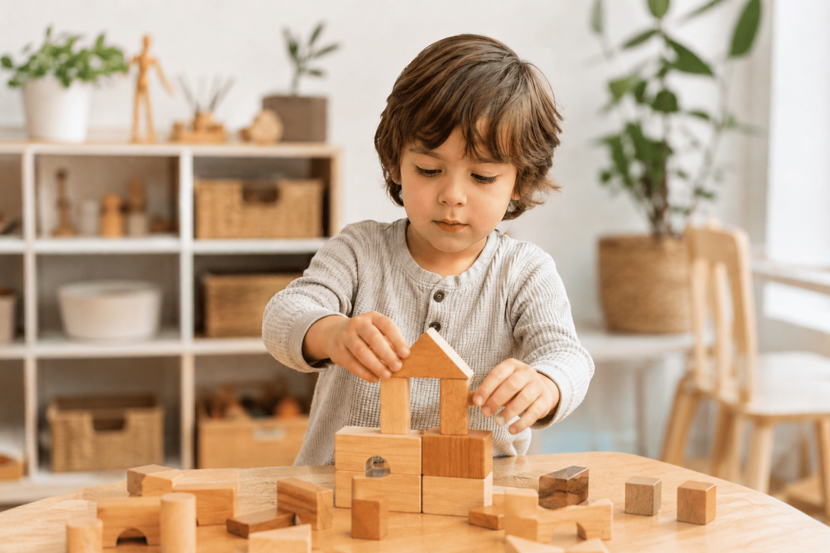 Child building with wooden blocks and open-ended toys for problem solving