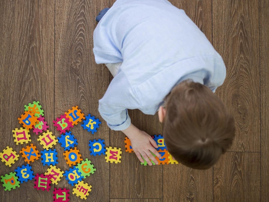 preschool child solving a wooden Montessori puzzle at home